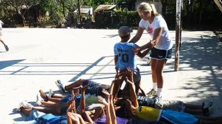 Nicola macht beim Sportunterricht mit den Kindern eine Vertrauensübung.