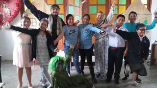 La foto de grupo muestra a ocho alumnos y alumnas disfrazados. Lynne y una compañera del servicio de voluntariado posan al fondo.