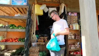 Ein Freiwilliger vor einem Obststand beim Einkaufen.