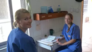 Swantje und Nora sitzen sich in der Klinik gegenüber und schauen in die Kamera.