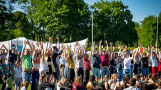 Young people raise their hands in the air.