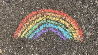 Regenbogen mit Kreise auf Asphalt gemalt.