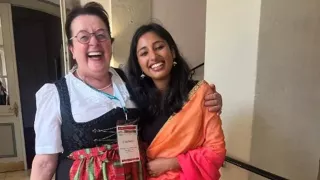 Zwei Frauen stehen direkt vor der Kamera und tragen traditionelle Kleidung aus Indien und Deutschland.