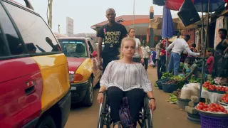 Auf dem Bild ist die weltwärts-Freiwillige Steffi zu sehen, die im Rollstuhl sitzt und auf dem Markt in Ghana unterwegs ist.