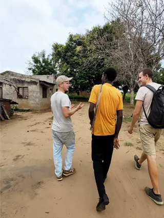 Jonas läuft neben seinen zwei Kollegen im Dorf Mkata. Die Besuche sind Teil der Projektarbeit in Tansania.