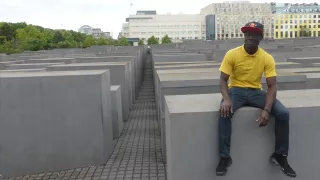 Amani est assise sur un pilier en béton sur le mémorial de l'Holocauste à Berlin.