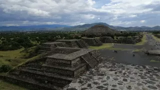 Paisaje panorámico con ruinas y una pirámide.