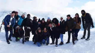 Foto de grupo de voluntarios y voluntarias en unos Alpes nevados.