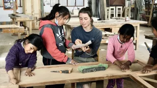 Als Handwerkerin ins Ausland. Die Kinder helfen der ausgebildeten Schreinerin bei der Renovierung der Tür.