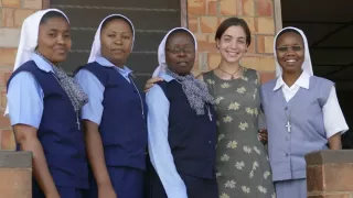 Die Freiwillige Hannah steht mit vier Ordensschwestern zusammen. Alle lächeln in die Kamera.