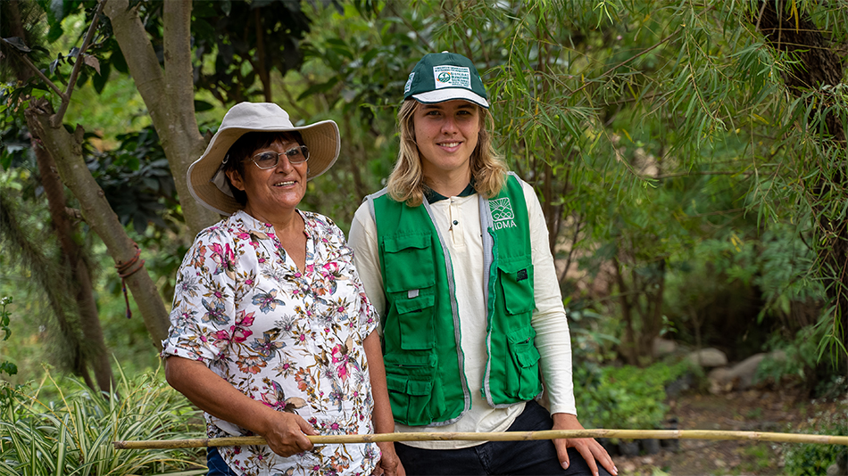 Leander hat sein Auslandsjahr nach dem Abi gemacht. Carmen Rosa und Leander stehen vor einer grünen Landschaft und lächeln in die Kamera.