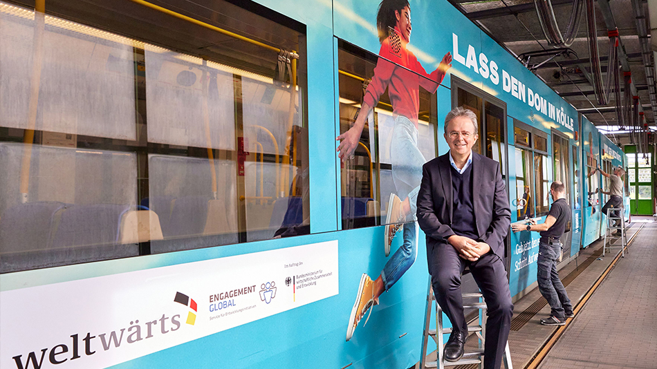 Dr. Jens Kreuter vor der Strassenbahn im weltwärts-Kampagnenlook